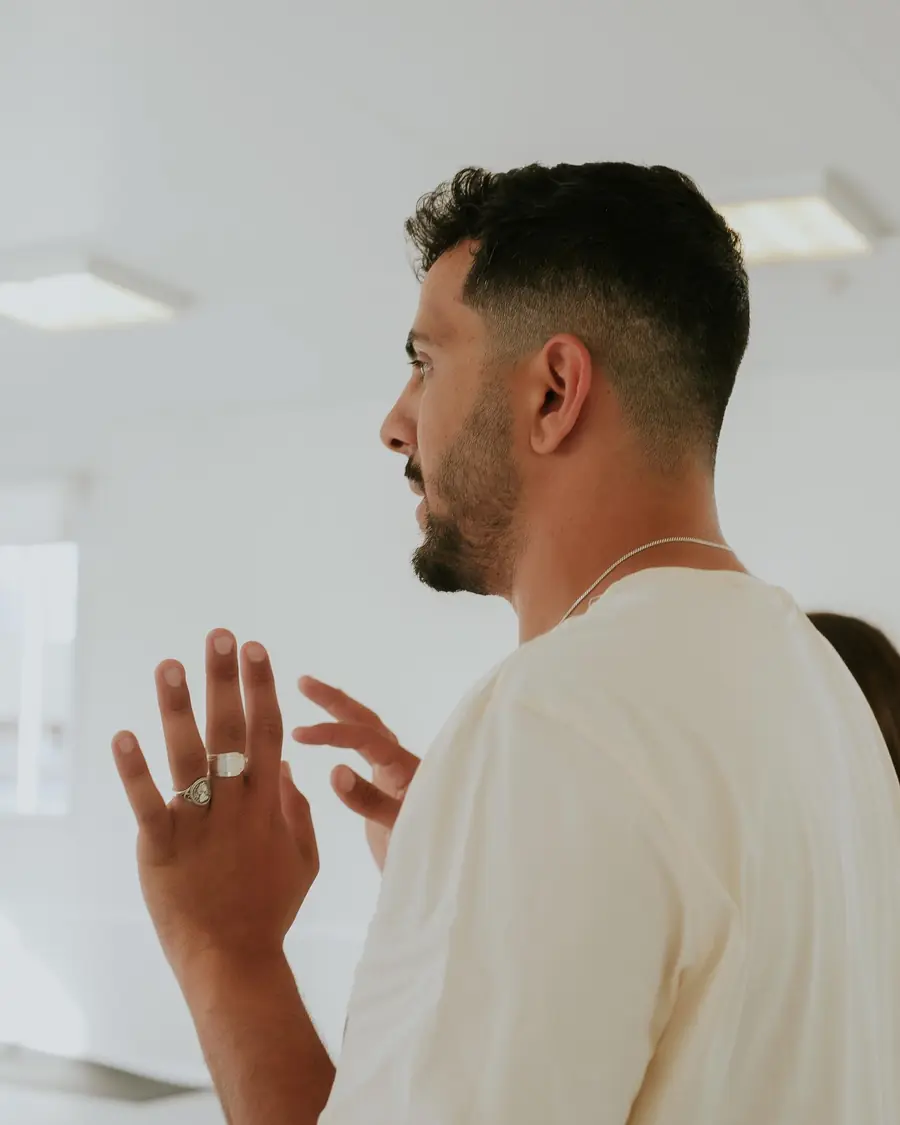 תומר ברקו, מייסד בארוק, מדבר ומסביר בתנועת ידיים, בחולצה לבנה